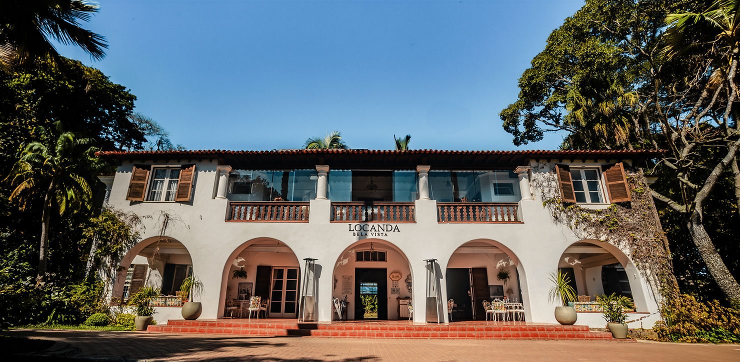 Fachada em arcos da Locanda Della Mimosa entre a mata da serra
