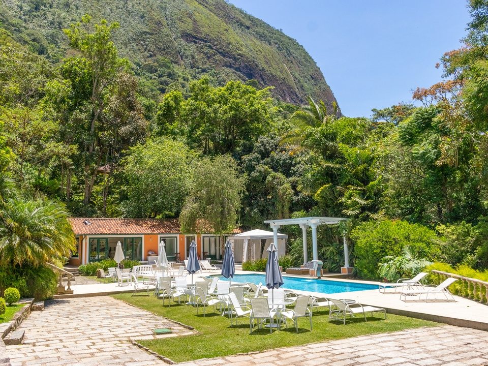Piscina cercada por jardins com o cost�o de pedra da serra