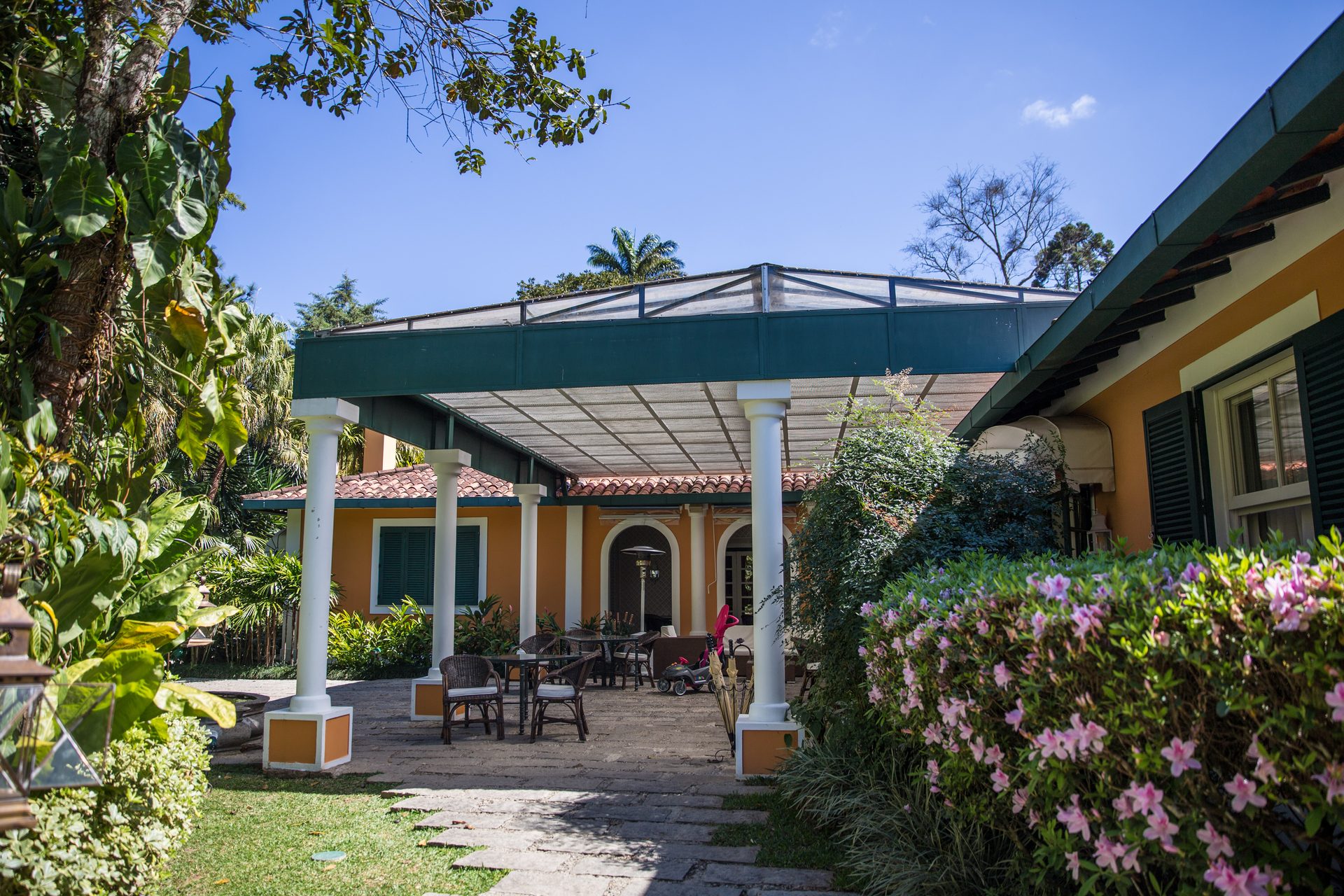 Pátio com pergolado e jardim florido da Locanda